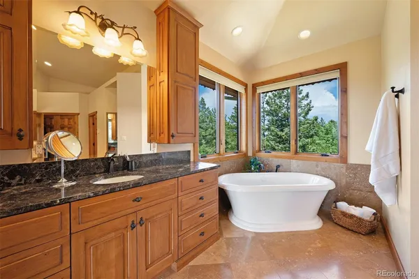 a spacious bathroom with a double vanity sink a large mirror and a bathtub next to a window