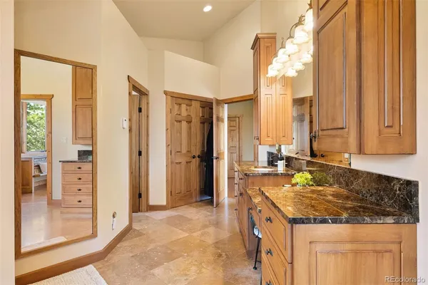 a bathroom with a granite countertop sink and a mirror