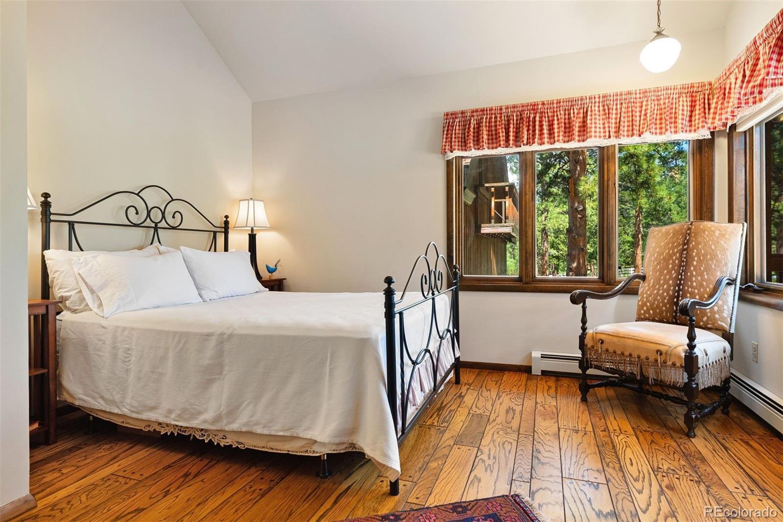 12351 South Ridge Road Conifer, CO 80433 - Photo 34 of 50 a bedroom with a bed and wooden floor