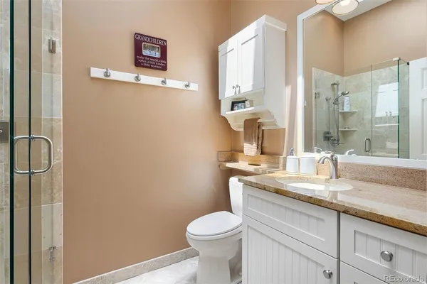 a bathroom with a granite countertop sink toilet and shower
