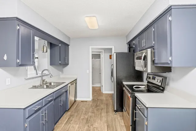 a kitchen with a sink stove and refrigerator
