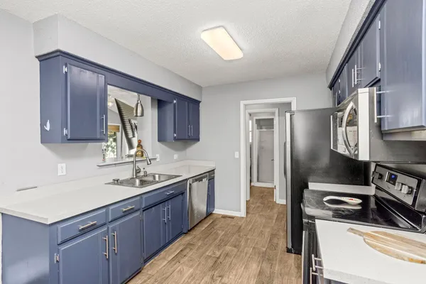 a kitchen with stainless steel appliances granite countertop a sink stove and refrigerator