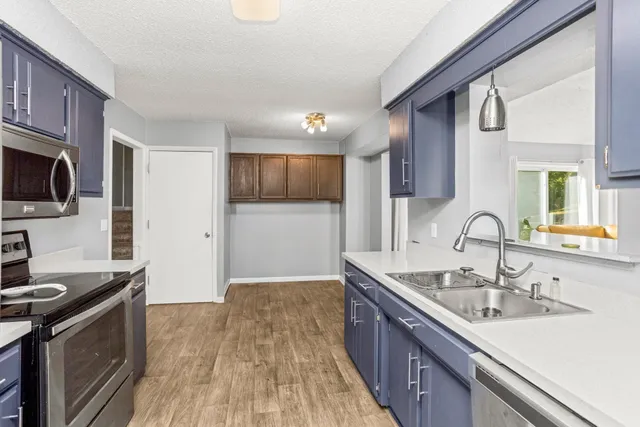 a kitchen with a sink appliances and cabinets