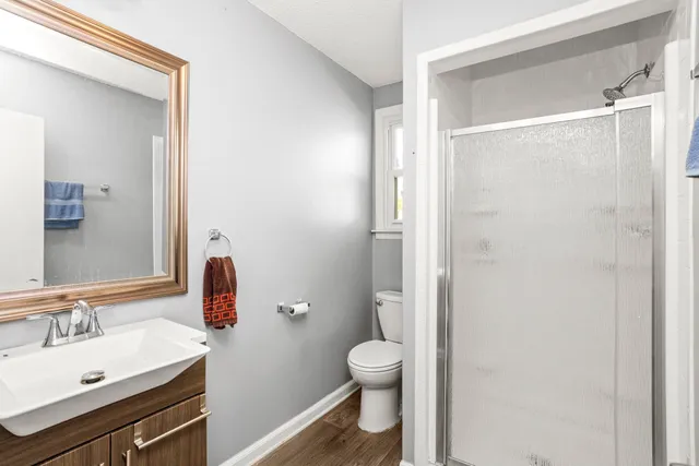 a bathroom with a sink a toilet and shower