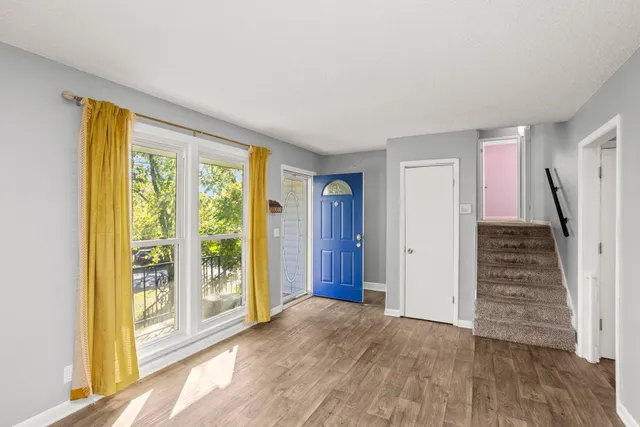 a view of an empty room with wooden floor and windows