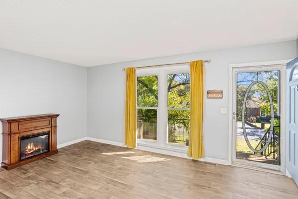 a view of an empty room with floor to ceiling window and wooden floor