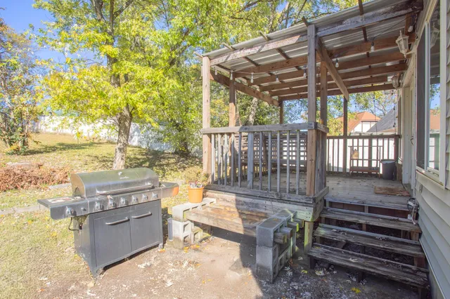 a view of a backyard with wooden floor and iron fence