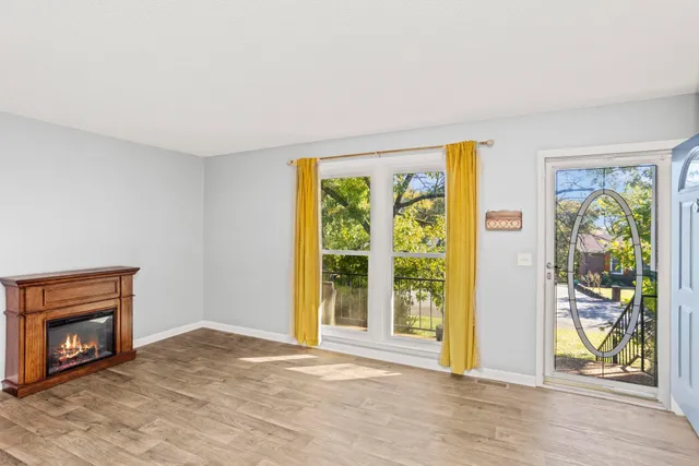 a view of an empty room with floor to ceiling window and wooden floor