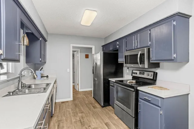 a kitchen with a sink stove and refrigerator