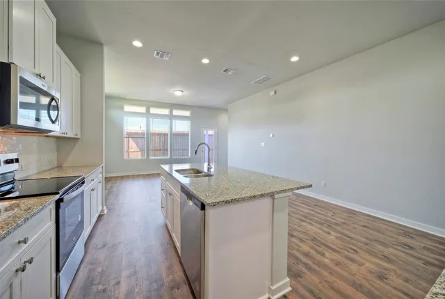 a kitchen with granite countertop a stove and a sink