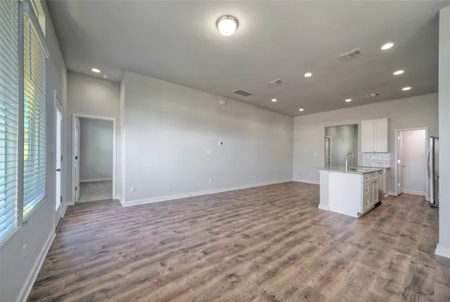 an empty room and kitchen with a sink