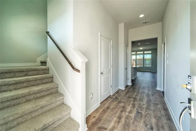 a view of a hallway with wooden floor and entryway