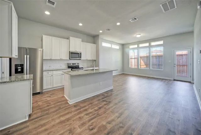 a kitchen with stainless steel appliances granite countertop a stove a sink and a refrigerator