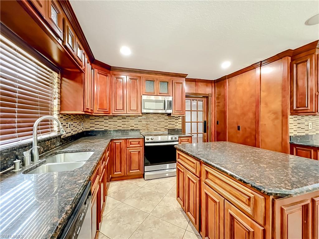 4200 South Hiawassee Road Orlando, FL 32835 - Photo 15 of 47 a kitchen with stainless steel appliances granite countertop a sink stove and cabinets