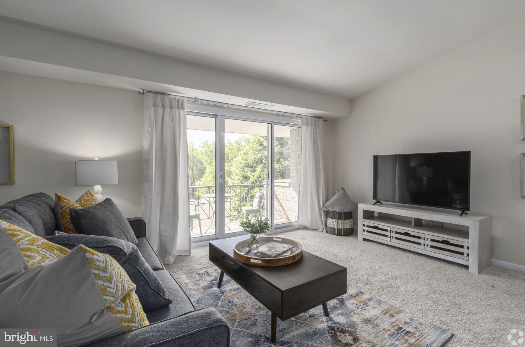 284 Iven Avenue, Unit 1B2701C Radnor, PA 19087 - Photo 7 of 12 a living room with furniture and a flat screen tv