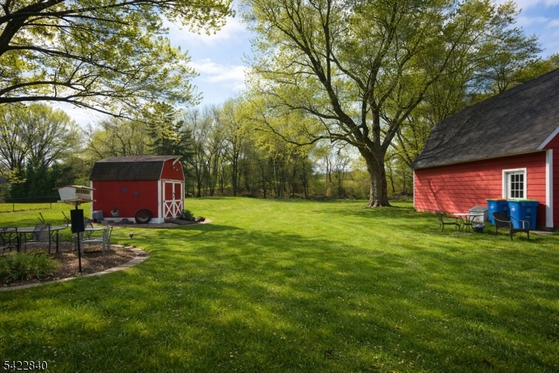 2142 South Branch Road Neshanic Station, NJ 08853 - Photo 29 of 48 a view of a backyard with table and chairs and a large tree