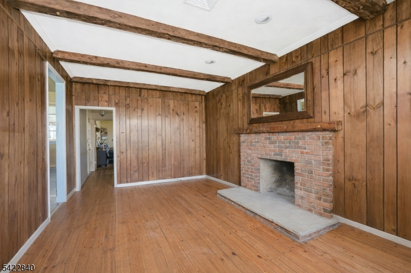 2142 South Branch Road Neshanic Station, NJ 08853 - Photo 43 of 48 a view of an empty room with wooden floor fireplace and a window