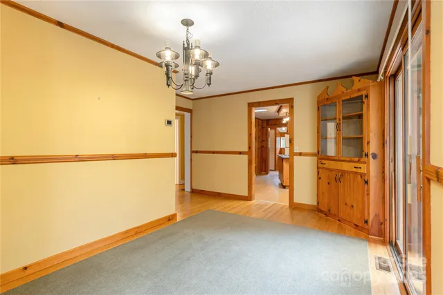 a view of an empty room and window with wooden floor