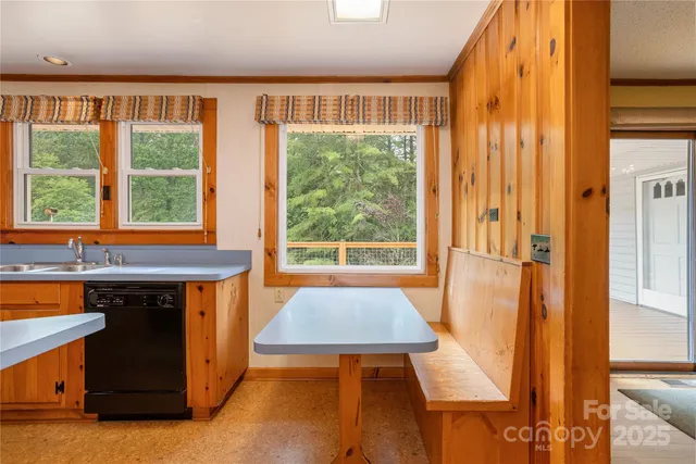 a view of an empty room with chandelier and a window