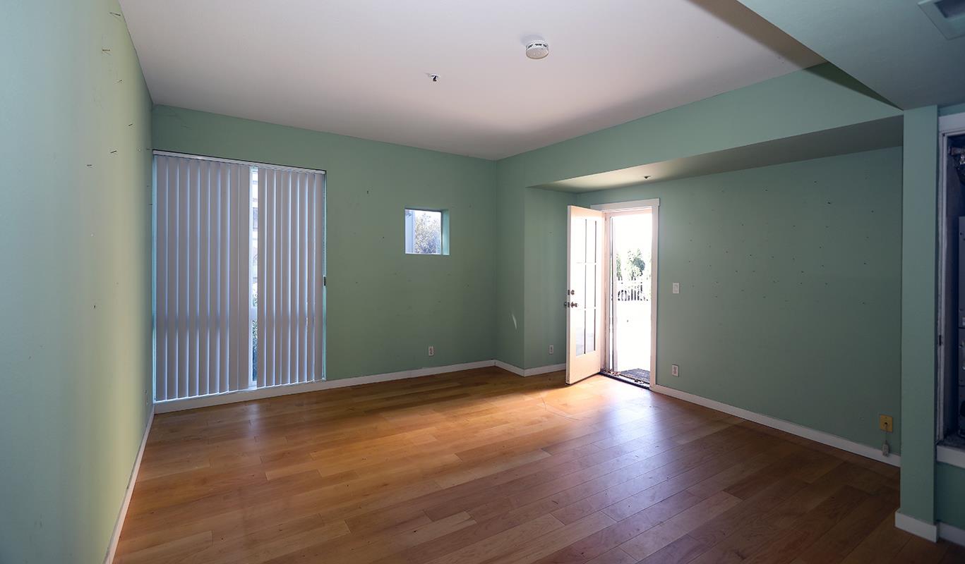 97 East St James Street, Unit 21 San Jose, CA 95112 - Photo 4 of 22 an empty room with wooden floor and windows
