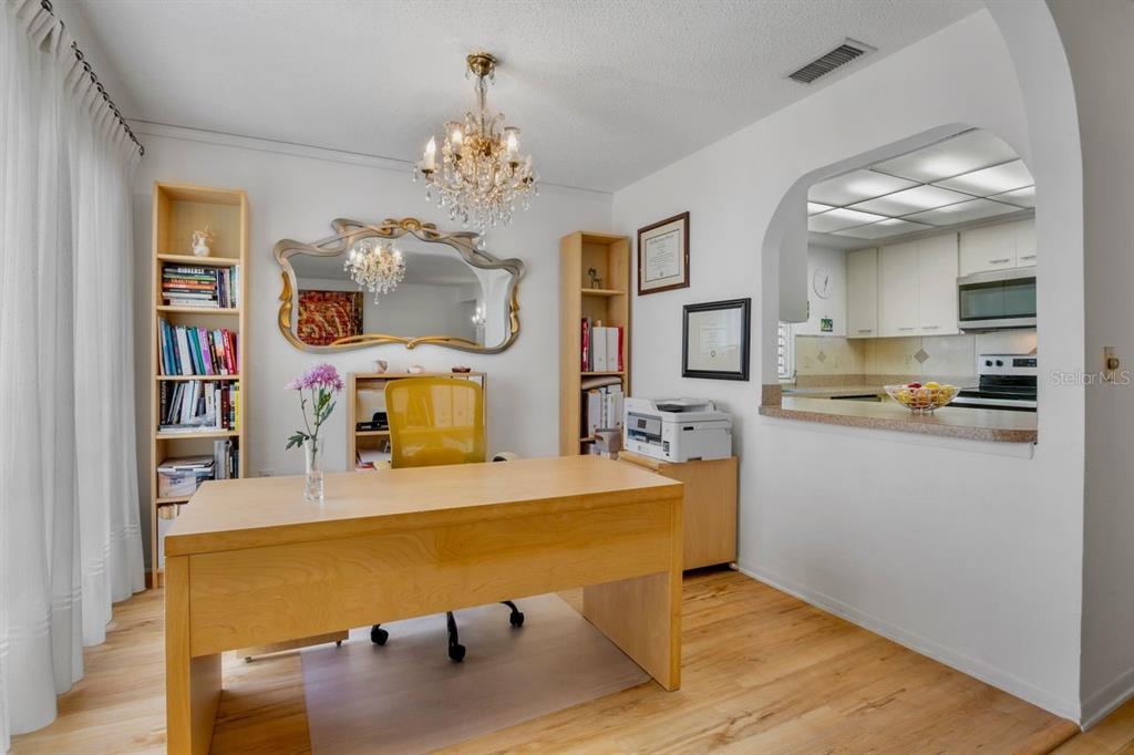 5150 Marsh Field Lane, Unit 120 Sarasota, FL 34235 - Photo 8 of 21 a bed room with a bed and a chandelier