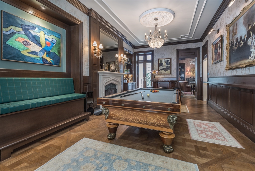 a living room with furniture a chandelier and a pool table