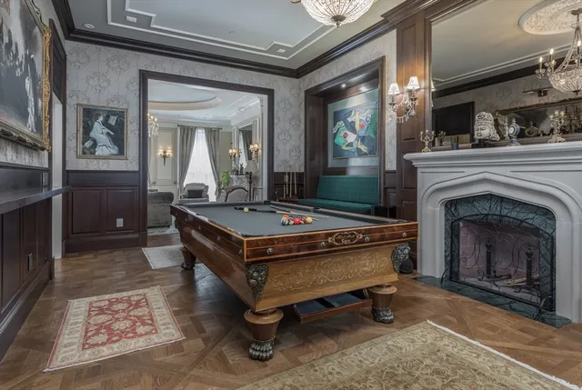 a room with pool table and paintings on the wall