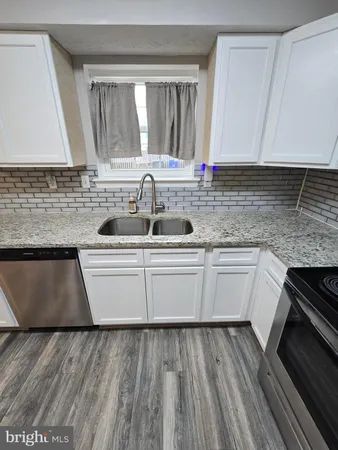 a kitchen with granite countertop a sink and a stove