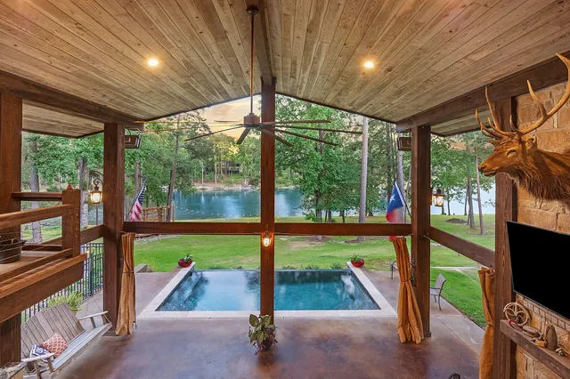 a view of an empty room with a floor to ceiling window and wooden floor
