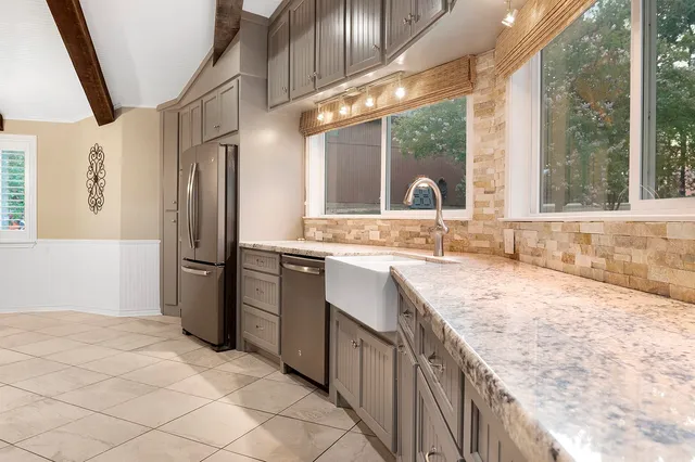 a kitchen with stainless steel appliances granite countertop a sink and a refrigerator