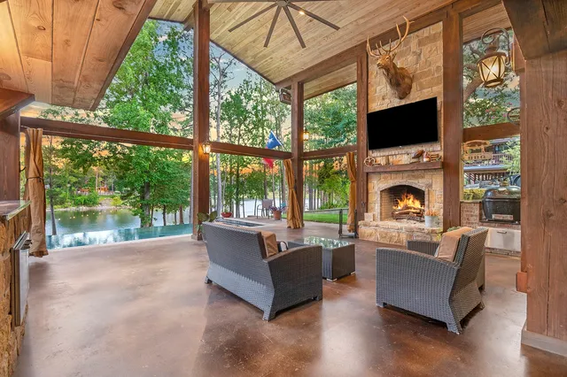 a living room with furniture a fireplace and a floor to ceiling window