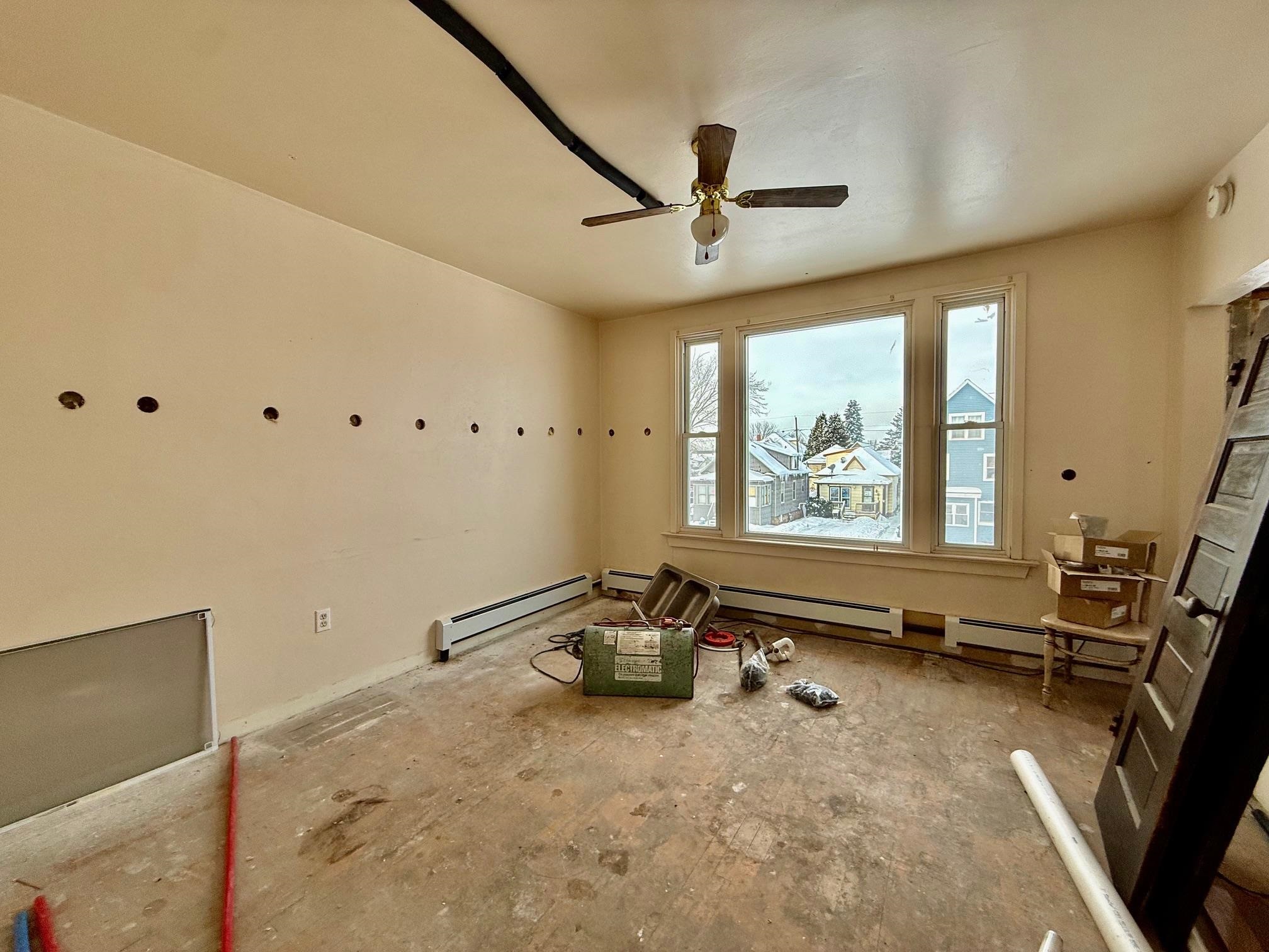 208 5th Street South Virginia, MN 55792 - Photo 3 of 9 Empty room featuring a baseboard heating unit and a ceiling fan