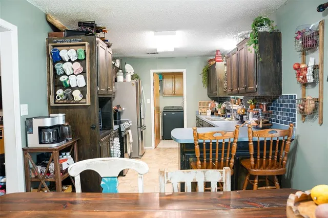 a kitchen with stainless steel appliances kitchen island granite countertop a refrigerator a stove top oven and a sink