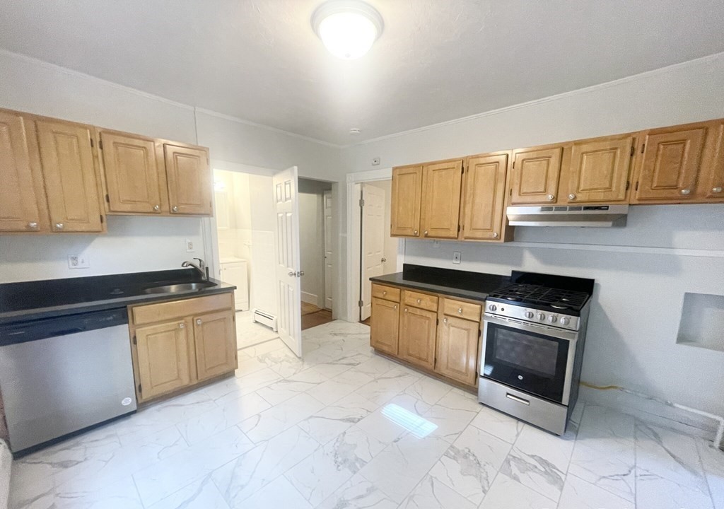 22 Howell Street, Unit 3 Boston, MA 02125 - Photo 1 of 9 a kitchen with granite countertop a stove a sink and a refrigerator