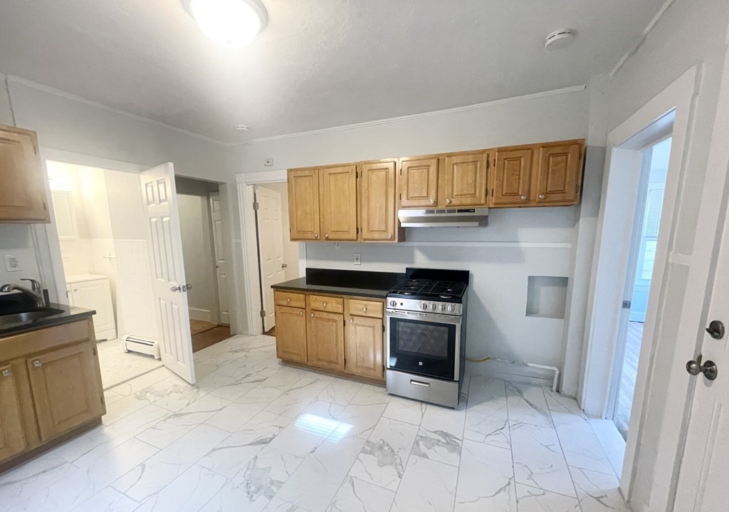 22 Howell Street, Unit 3 Boston, MA 02125 - Photo 2 of 9 a kitchen with granite countertop a stove a sink and a refrigerator