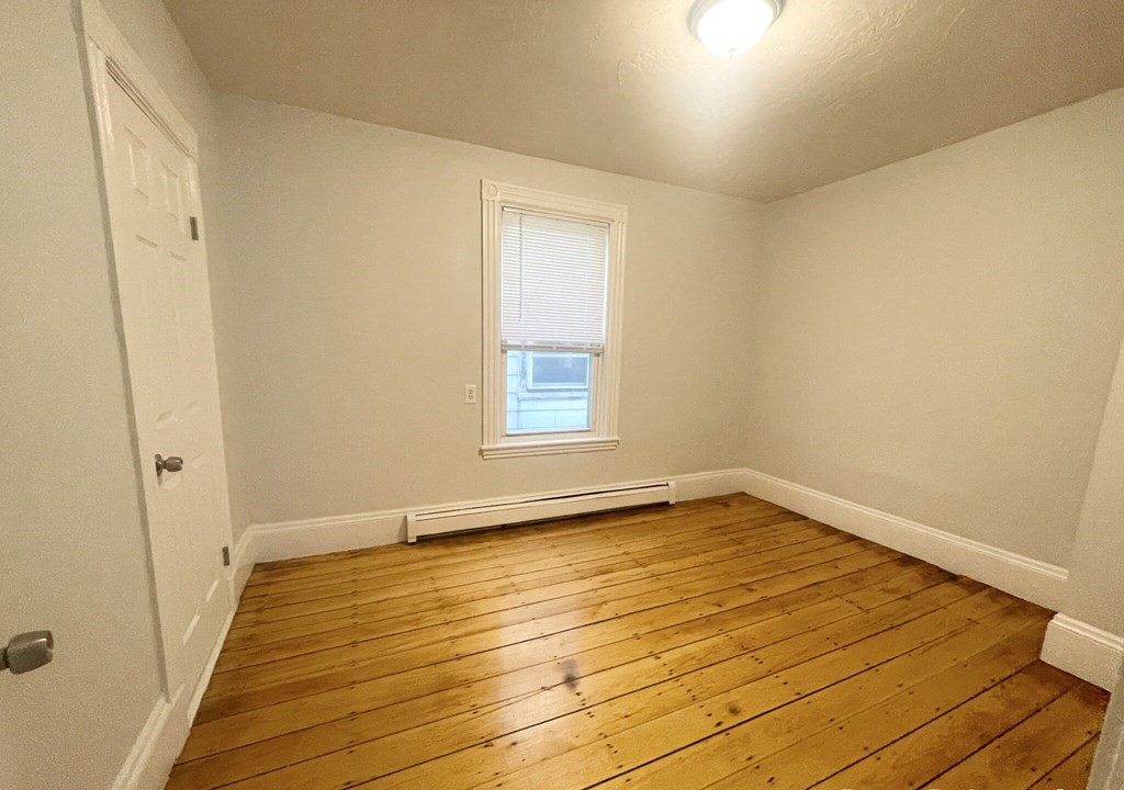 22 Howell Street, Unit 3 Boston, MA 02125 - Photo 4 of 9 a view of a room with wooden floor and white walls