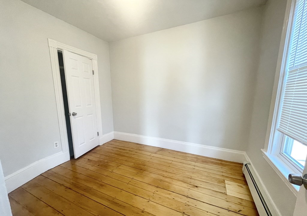 22 Howell Street, Unit 3 Boston, MA 02125 - Photo 6 of 9 an empty room with wooden floor and windows