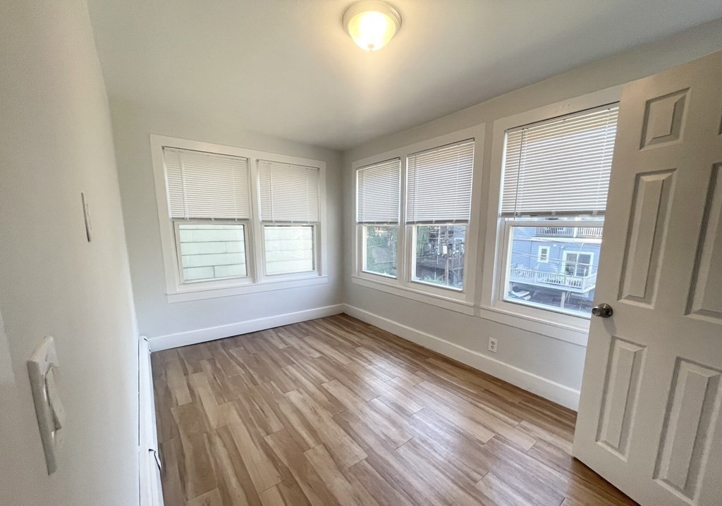 22 Howell Street, Unit 3 Boston, MA 02125 - Photo 8 of 9 a view of an empty room with wooden floor and a window