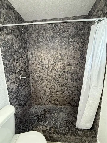 a bathroom with a toilet and a shower curtain