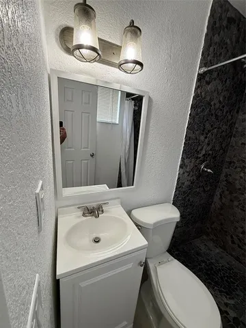 a bathroom with a sink toilet and shower