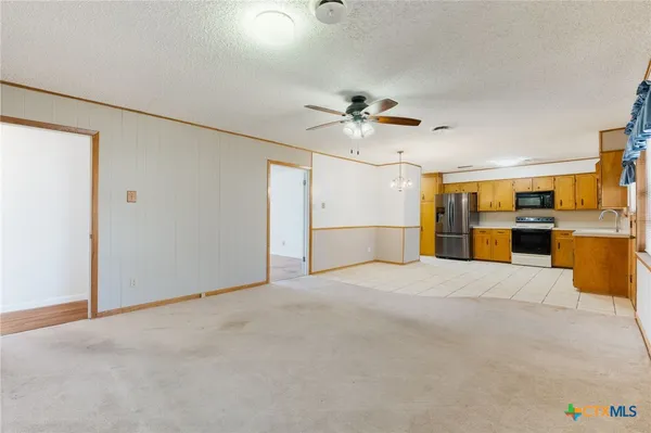 a view of large kitchen with a stove and a refrigerator