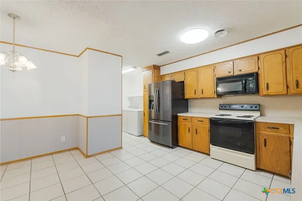 a kitchen with stainless steel appliances granite countertop a refrigerator a stove top oven a sink and dishwasher