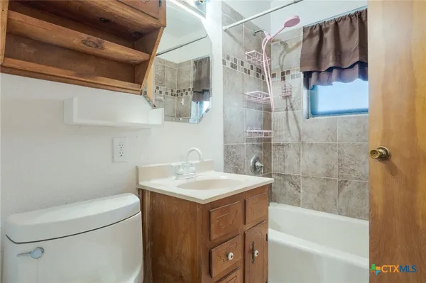 a bathroom with a sink vanity granite toilet and shower