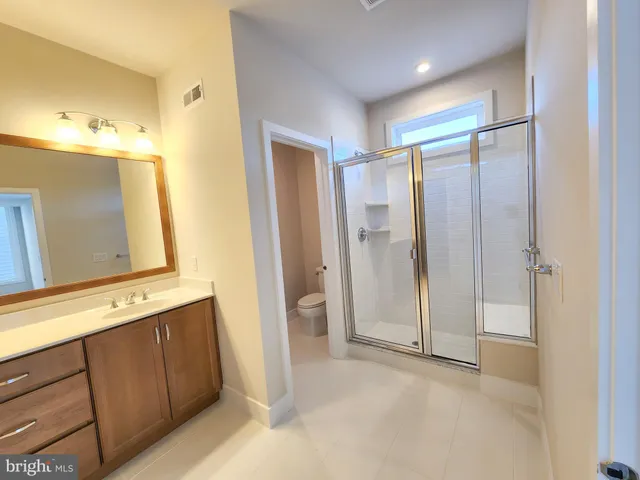a view of a bathroom with a sink a mirror and a shower