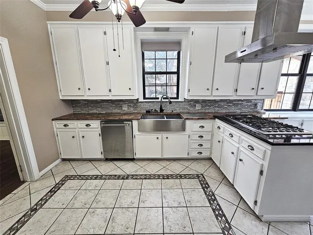 a kitchen with a white cabinets and chandelier