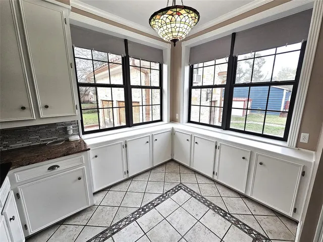 a kitchen with granite countertop white cabinets and stainless steel appliances