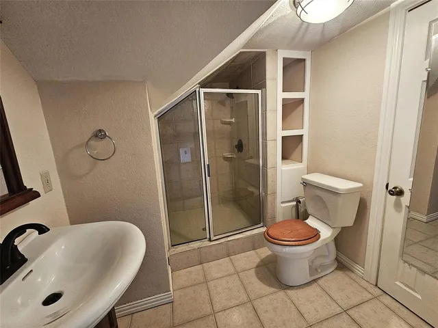 a bedroom with a bed a chandelier and wooden floor