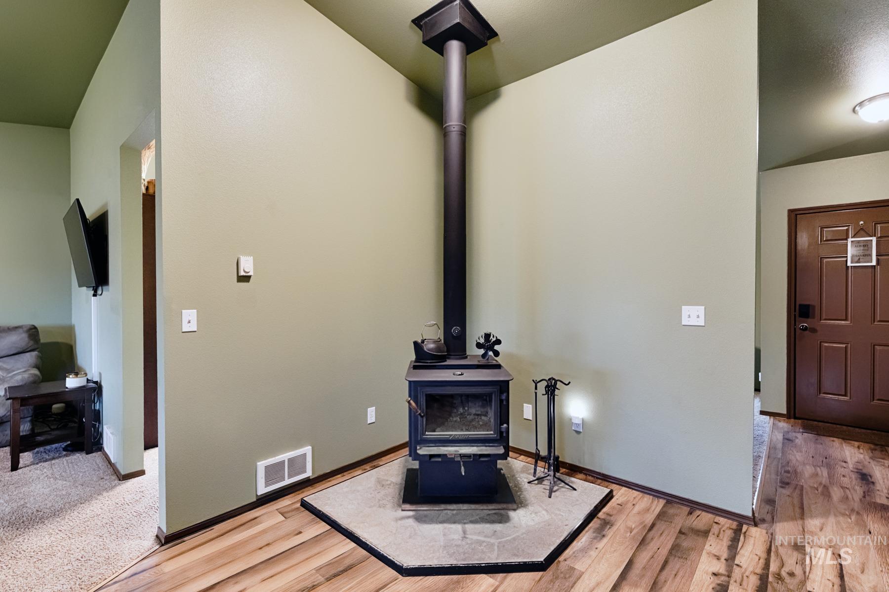 7500 Pleasant View Drive Caldwell, ID 83607 - Photo 9 of 43 Detailed view of a wood stove and wood finished floors