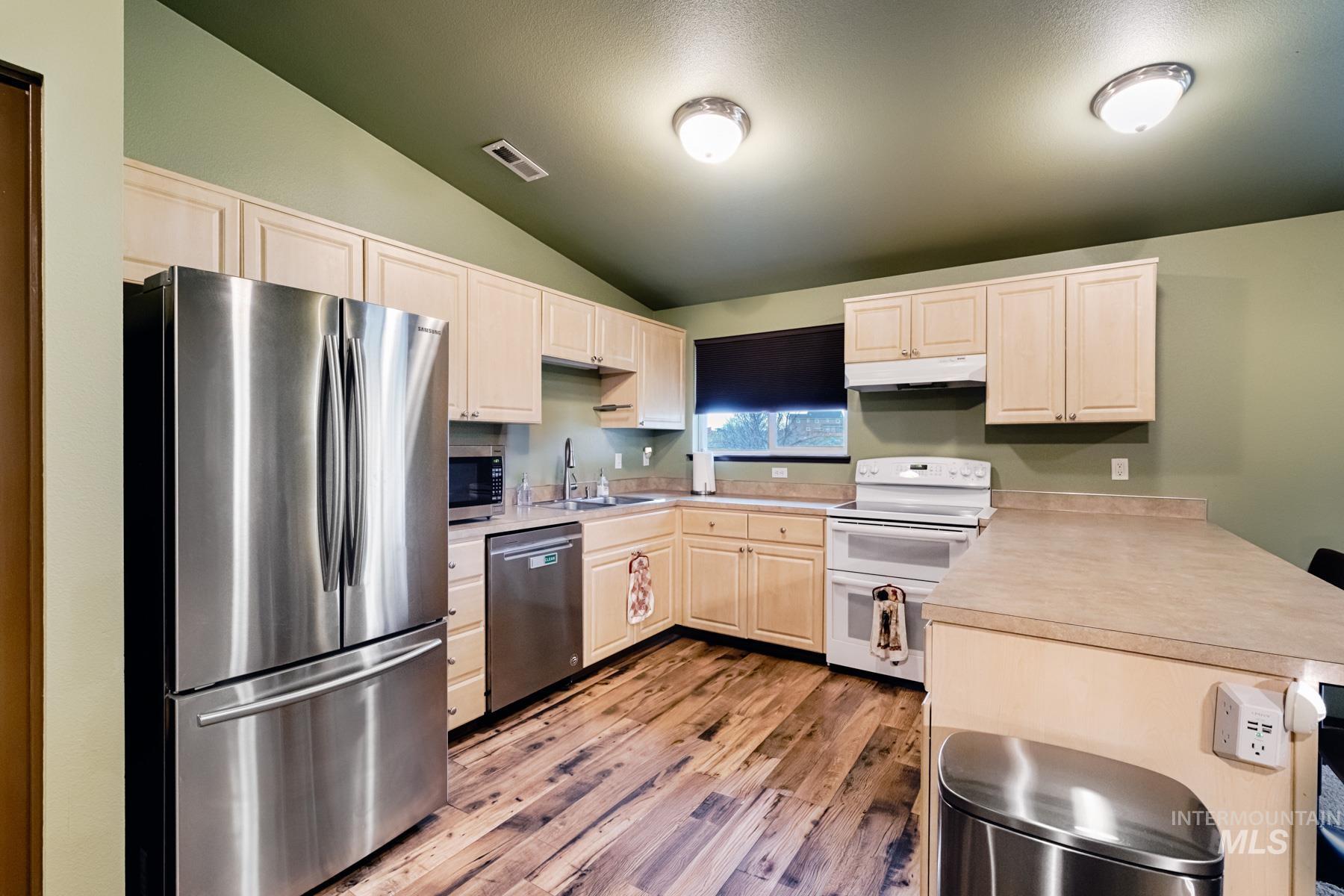 7500 Pleasant View Drive Caldwell, ID 83607 - Photo 5 of 43 Kitchen featuring stainless steel appliances, lofted ceiling, light countertops, light wood finished floors, and light wood finish cabinets