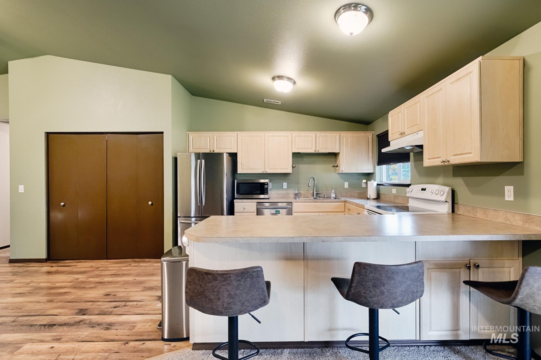 7500 Pleasant View Drive Caldwell, ID 83607 - Photo 6 of 43 Kitchen with light countertops, stainless steel appliances, a breakfast bar area, vaulted ceiling, and a peninsula